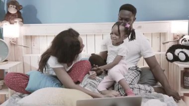 Komik sevimli Afrikalı ebeveynler küçük kızlarıyla oynuyorlar. Mutlu aile portresi. Hafta sonları evde birlikte vakit geçiriyorlar..