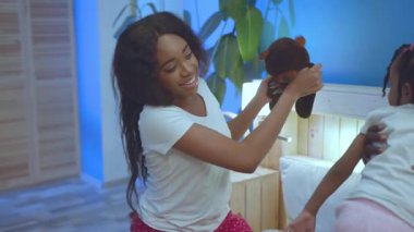 Mutlu siyah Afrikalı anne ve babaların bebekleriyle oynadığı portreler. Evde yatakta iyi vakit geçiriyorlar..