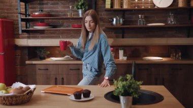 Çekici, serbest çalışan, kahve içen genç bir kadın. Evdeki mutfakta çalışmaya başlıyor. Siyah ekrana bakarken dizüstü bilgisayarla sorun yaşayan utangaç bir kızın portresi.