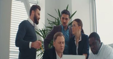 Şirketler genç iş kollektifleri dizüstü bilgisayara bakıyor, sunumu izliyor ve modern ofiste yeni projeleri tartışıyorlar. Çok kültürlü. Kapalı.