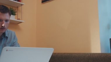 Ciddi bir genç adam masada oturmuş ünlü bir şirketin ofisindeki dizüstü bilgisayara bakıyor. İyi adam önemli bir proje hazırlıyor. İçeride. Yakın plan..