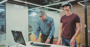 NEW YORK - 5 Nisan 2017: Bilim Merkezi 'nde yeni yazılım kullanan akıllı yakışıklı programcı. Sanal gerçeklik gözlüklü çekici adam başka bir gerçekliği izliyor. Kapalı.