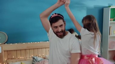 Ev yapımı Disney partisinde eğlenceli zamanlar. Küçük mutlu kız babasının etrafında dans ediyor ve prenses gibi gülümsüyor..