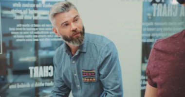 NEW YORK - 5 Nisan 2017: Masanın yanında duran iki yakışıklı beyaz adam. Genç yakışıklı çocuk yeni icadı test ediyor. Sanal gerçeklik gözlüklü öğrenci. Yakın plan..