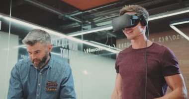 NEW YORK - 5 Nisan 2017: İki sevimli programcı sanal gerçeklik gözlükleriyle bilgisayarı test ediyor. Genç yakışıklı adam gülümsüyor, Bilim Merkezi 'ne bakıyor. Kapalı.