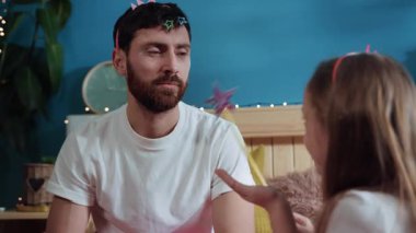 Mutlu baba-kız yatak odasında birlikte perilik oynuyorlar. Yakından bakınca, babasının yüzüne kozmetik tozu üfleyen tatlı bir kız onu güzel bir prensese dönüştürüyor..