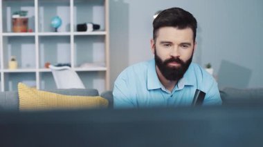 Düşünceli bir adam, rahat ve davetkar bir yaşam alanında dinlenirken televizyon izlemekle derinden meşguldür.