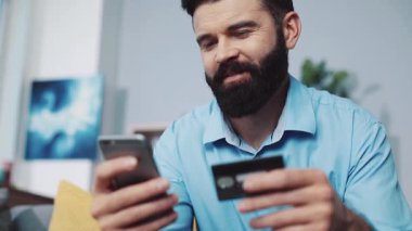 Çevrimiçi ödemelerini iyi yöneten bir adamın kredi kartıyla birlikte akıllı telefonunu kullandığını düşün.