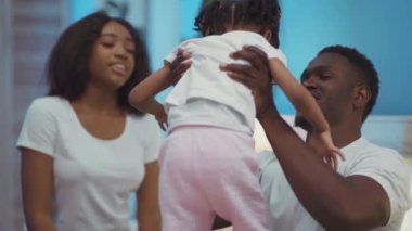 Şirin Afro-Amerikalı, çocuklu, gülümseyen ve kucaklaşan bir aile. Ebeveynlerin ve çocukların güzel portresi..