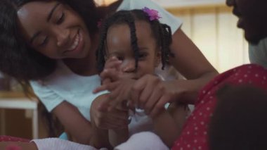 Saçları örgü örmüş, annesiyle el çırpıp gülümseyen komik Afrikalı kızın sevimli yakın çekimi. Anne ve kızın kucaklaşıp oynadığı güzel aile portresi..