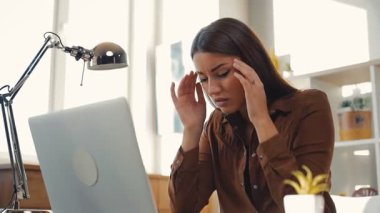 Kahverengi saçlı hoş bir genç kız evdeki masada oturuyor. Gündelik giysiler içinde çekici bir öğrenci başını tutuyor, tapınaklara masaj yapıyor. Kapalı.