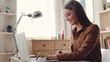 Prestijli üniversite yazma tezinin genç mezunuyum. Gözlüklü güzel kız dizüstü bilgisayarda oturuyor, çalışıyor. Gündüz.