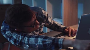 Görünürde yorgun bir birey, uzun ve zorlu bir iş seansı sırasında masalarının üzerine yığılır.