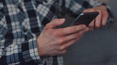 Modern teknolojinin günlük hayatta nasıl kullanıldığını gösteren, akıllı bir telefonu güvenli bir şekilde tutan ellerin yakın plan görüntüsü.