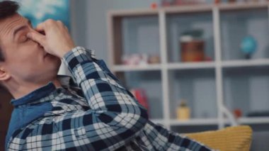 Bir insan dizüstü bilgisayarında, rahat bir koltuğa oturmuş uzaktan çalışma kültürünü somutlaştırıyor.