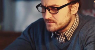 Gözlüklü, yoğun bir şekilde çalışan ya da masa başında çalışan kendini işine adamış bir birey.