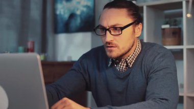 Kendini işine adamış, rahat ve modern bir çalışma alanında dizüstü bilgisayarda üretken bir iş yapan biri.