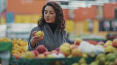 Meyve sebze pazarından elma seçen çekici genç bir kadın. Hayat tarzı, ticaret ürünü. Taze müşteriler.