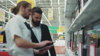 NEW YORK - 5 Nisan 2017: Portre satıcısı danışmanı, teknoloji mağazasındaki genç sakallı adamla, el alışverişi elektroniği teknolojisi, internet alışveriş merkezi, yavaş çekim, tablet bilgisayarı kullanın.