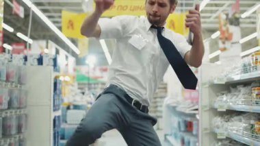 Mutlu adam. Teknoloji bölümünde satıcı dans ediyor. Süpermarkette tablet bilgisayar tutuyor. İş yerinde elektronik el alışverişi yapıyor.