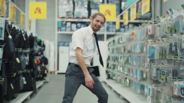 NEW YORK - 5 Nisan 2017: Gülümseyen adam, teknoloji bölümünde dans eden kişi, süpermarkette tablet bilgisayar kullanıyor.