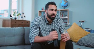 Genç ve çekici bir adamın portresi bira içip futbol seyrediyor. Kanepede yalnız başına oturan bir takıma tezahürat yapıyor. Kanepede alkol alıyor.