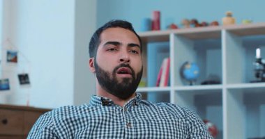 Yorgun, yakışıklı, kanepede oturan genç adam TV 'ye bakıyor. Evdeki tutuşu kaldırıyor, uyuyor. Canı sıkılıyor, canı sıkılıyor.