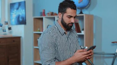 ciddi çekici genç adam telefon kullan kanepeye otur akıllı telefon eller elektronik uygulama tut mesaj yaz yakışıklı portre yakın bağlantı eğlence yaşam tarzı iletişimi dokun