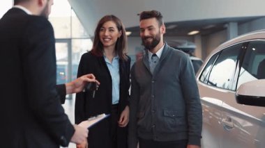 Yeni alınmış bir arabanın yanında duran güzel genç insanlar. Satıcı genç adama anahtarları veriyor, el sıkışıyor. Kız tebrik ediyor, sarılıyor..