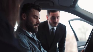 Çekici bir araba satıcısı danışmanı bu araba modelini potansiyel alıcılara almanın faydalarını anlatıyor. Genç adam sorular soruyor ve cevaplar alıyor..