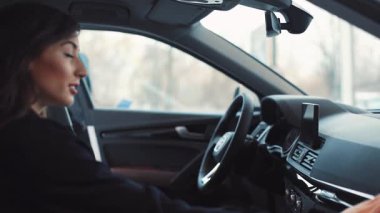 Şoförün yanındaki arabada oturan güzel kız. Arabada oturan sakallı mutlu genç adam. Çift konuşuyor, gülümsüyor..