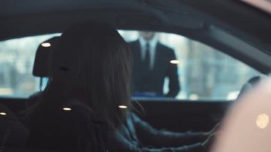 Arabanın kabininde oturan iki genç insan. Aşık güzel bir çift sevilen otomobil modelini satın alıyor. Dikiz aynasına bakan çekici kız, saçları ayarlıyor..