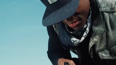 NEW YORK - 5 Nisan 2017: Afro-Amerikan bir adamın savunmasız bir adama silahla saldırdığını ve kurbanı yere yapıştırdığını yakından görmek. Suçlu bir adama silah doğrultuyor. Kamera dengeleyici görüntüsü