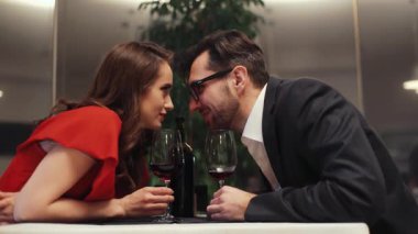 Güzel, beyaz, aşık bir çift masada gözlükleriyle oturuyor. Genç adam ve kadın konuşuyor, birbirlerine bakıyorlar. Romantik atmosfer.