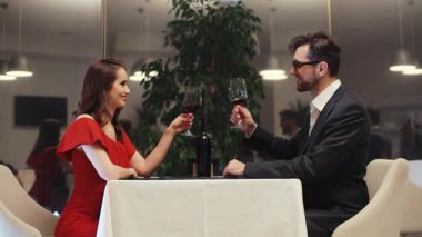 Birbirine aşık genç bir çift masada oturmuş şarap içiyor. Beyaz bir kızın önünde oturan sakallı yakışıklı bir adam. Kapalı.