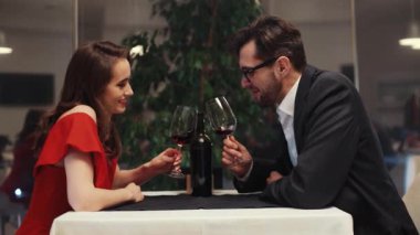 Birbirine aşık genç bir çift masada oturmuş şarap içiyor. Beyaz bir kızın önünde oturan sakallı yakışıklı bir adam. Kapalı.