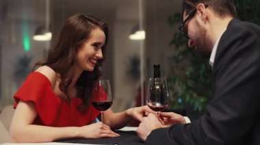 Birbirine aşık genç bir çift masada oturmuş şarap içiyor. Beyaz bir kızın önünde oturan sakallı yakışıklı bir adam. Kapalı.