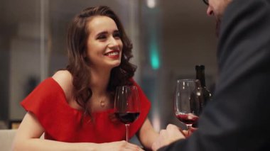 Birbirine aşık genç bir çift masada oturmuş şarap içiyor. Beyaz bir kızın önünde oturan sakallı yakışıklı bir adam. Kapalı.