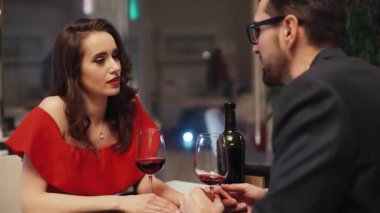Birbirine aşık genç bir çift masada oturmuş şarap içiyor. Beyaz bir kızın önünde oturan sakallı yakışıklı bir adam. Kapalı.