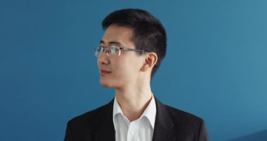 Başarılı genç Çinli bir yöneticinin portresi ofiste kameraya bakıyor gülümsüyor Asyalı yakışıklı, yakışıklı, yakışıklı iş adamı ceketi yavaş çekimde.