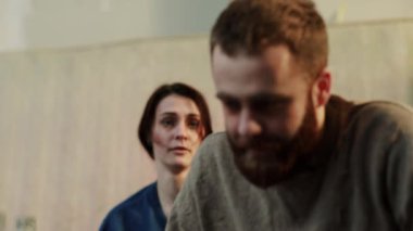 Sakallı sarhoş bir adam evde bir kadınla bira kavgası yapar. Kanepede oturur. Alkol içer, içki içer.