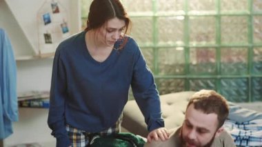 Kadın sinirli genç alkolik adama yardım ediyor. Kanepede oturuyor. Stresli, çaresiz, alkolik, alkolik, içki içiyor.