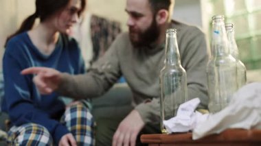 Biberonu kapat sarhoş adam bağırıyor kadın alkolik kanepeye otur üzgün stres alkolik adam yorgun parti kadını kadın şişe yavaş çekim yakın portre