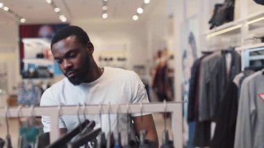 NEW YORK - 5 Nisan 2017: Çekici Afro-Amerikan erkeği elbise seçti alışveriş merkezi tasarımı, moda alışverişi, güzellik, güzel günlük model yakın çekim kot portresi