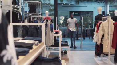 NEW YORK - 5 Nisan 2017: Çekici Afro-Amerikan erkeği elbise seçti alışveriş merkezi tasarımı, moda alışverişi, güzellik, güzel günlük model tarzı yakın çekim, yakışıklı yavaş çekim portresi