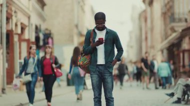 NEW YORK - 5 Nisan 2017: Gözlüklü Afrikalı Amerikalı şehir teknolojisinde telefon kullanıyor iş adamları meşgul insanlar modern siyah gülümseme yakışıklı hayat tarzı hırslı akıllı telefon