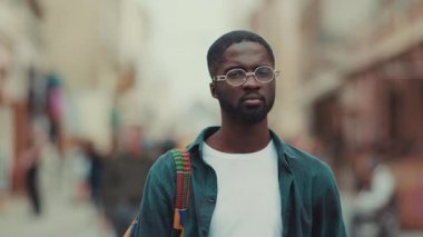 Gözlüklü genç Afro-Amerikan portresi. Gülümse, mutlu ol. Açık havada dur, mutlu ol.