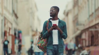 NEW YORK - 5 Nisan 2017: Afrikalı Amerikalı mutlu genç turist standı Avrupa 'da gezen telefon kullan yakışıklı sokak siyahi portresiyle yüz yüze