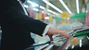 Yaklaş sakallı yakışıklı genç adam teknoloji mağazasında telefon kullan. Elektronik el alışverişi, cep telefonu teknolojisi. İnternet gezici alışveriş merkezi yavaş çekim portresi.