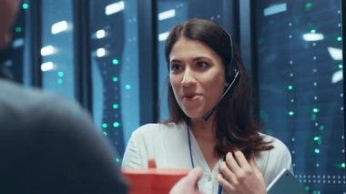 Bir bilişim uzmanı yüksek teknoloji veri merkezinde karmaşık sistemleri yönetmek ve izlemek için özel bir kulaklık kullanır